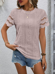 Pink blouse with eyelet details and scalloped short sleeves.