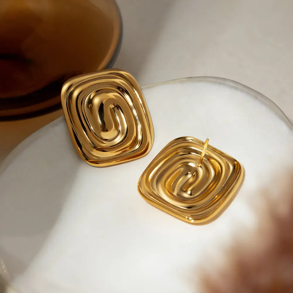 Gold sculpted swirl square earrings with a contemporary, chic design.