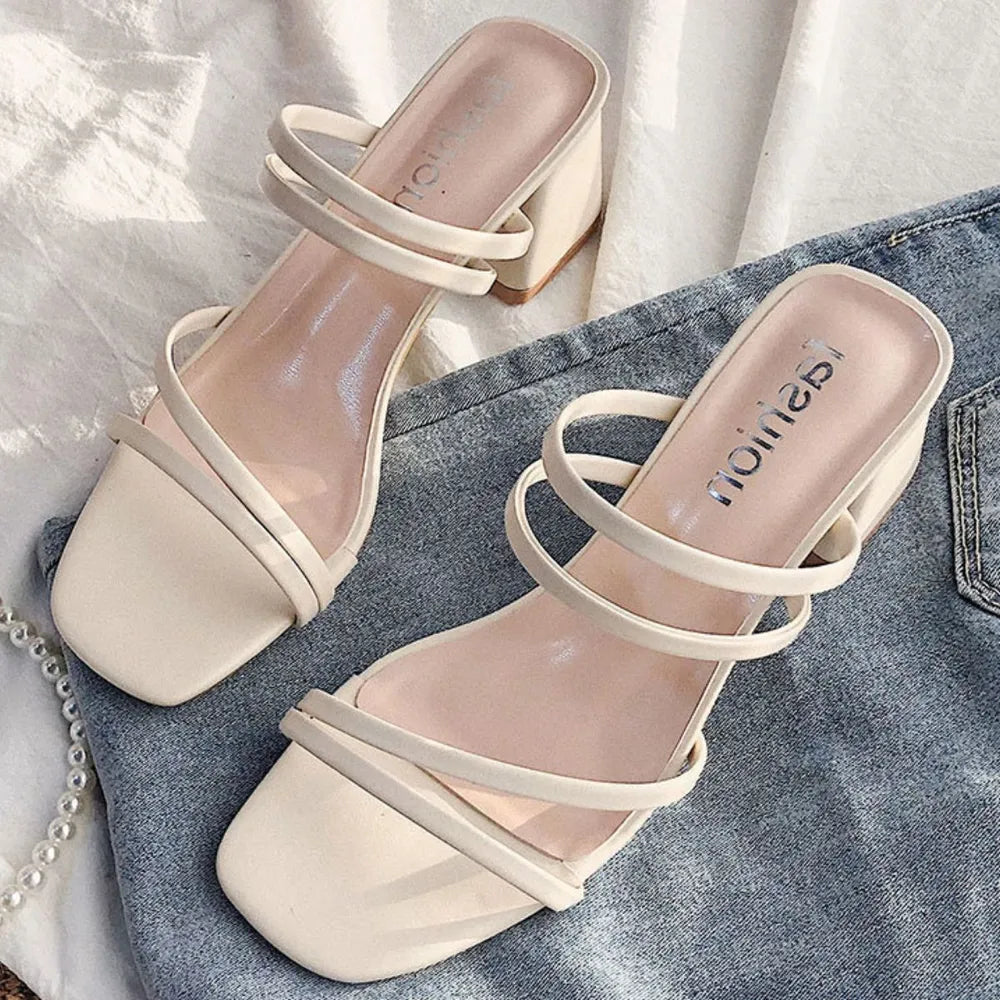 Beige strappy minimalist block heel mules with double thin straps and square toe.