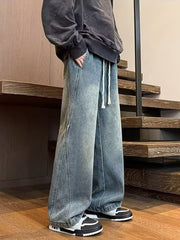 Men's blue washed wide leg jeans with drawstring waist and contrast stitching.