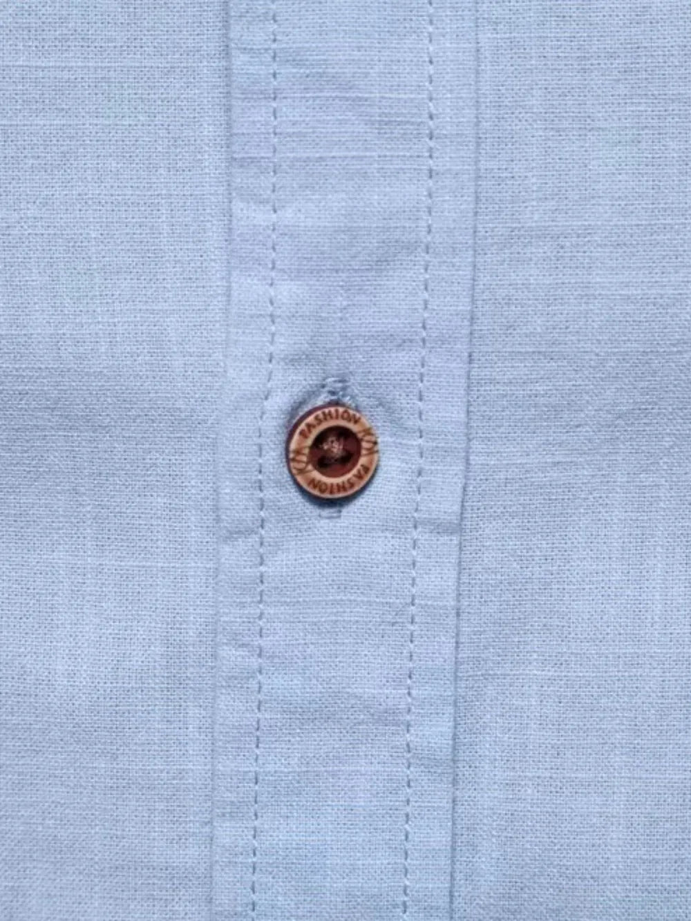 Light blue linen shirt with embroidered button detail.