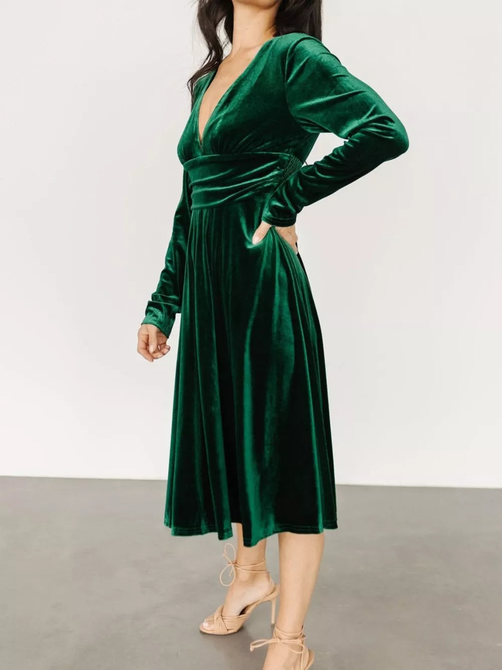 Dark green velvet midi dress with V-neck, long sleeves, and cinched waist.