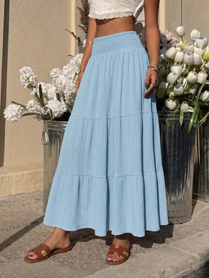Blue smocked tiered maxi skirt with flowing elegance and textured fabric.