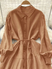 Caramel textured tiered long sleeve button-down dress with cinched waist and smocked cuffs.