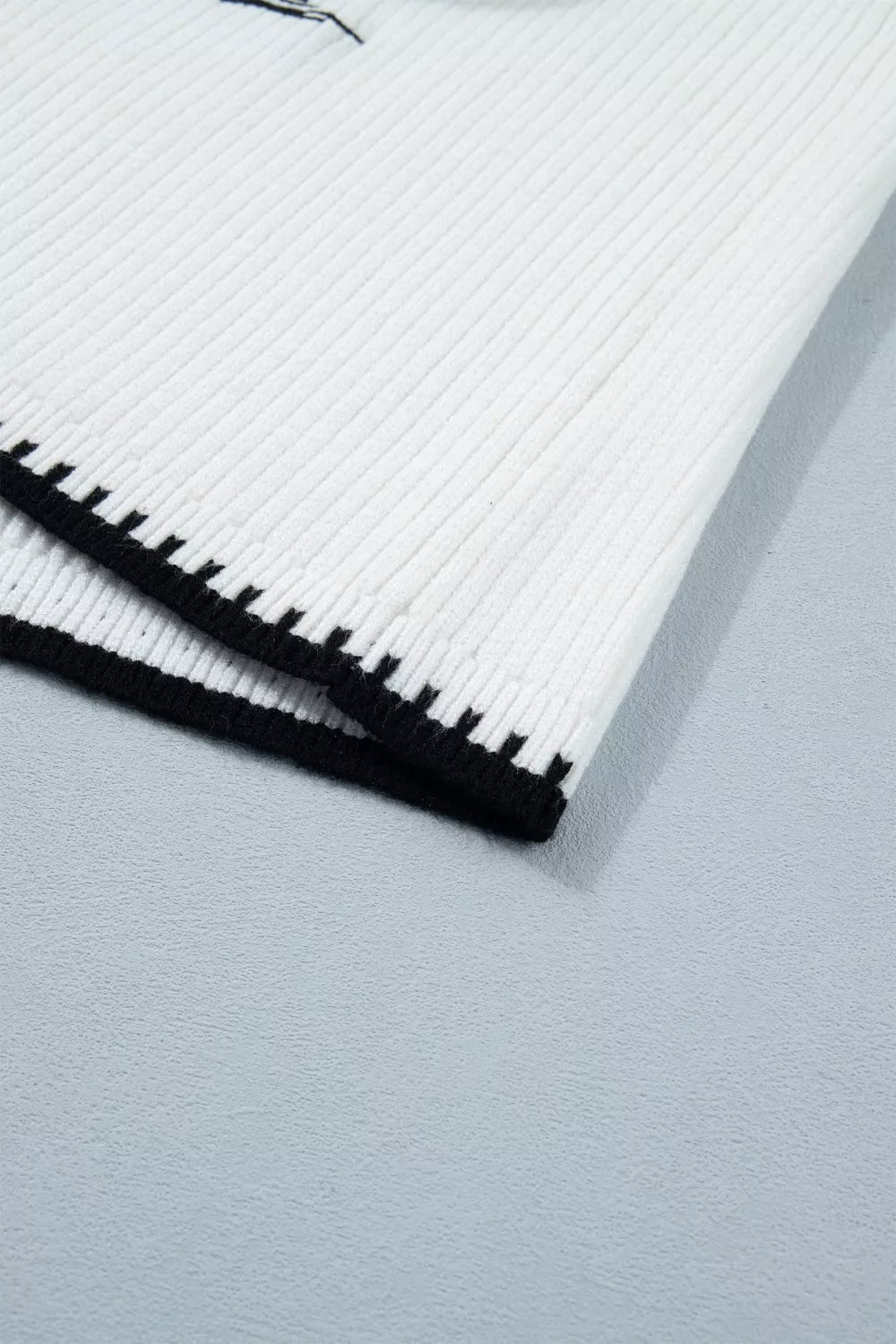 White ribbed sweater vest with black contrast trim detail