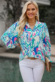 Women's abstract print blouse with gathered cuffs in blue and pink.