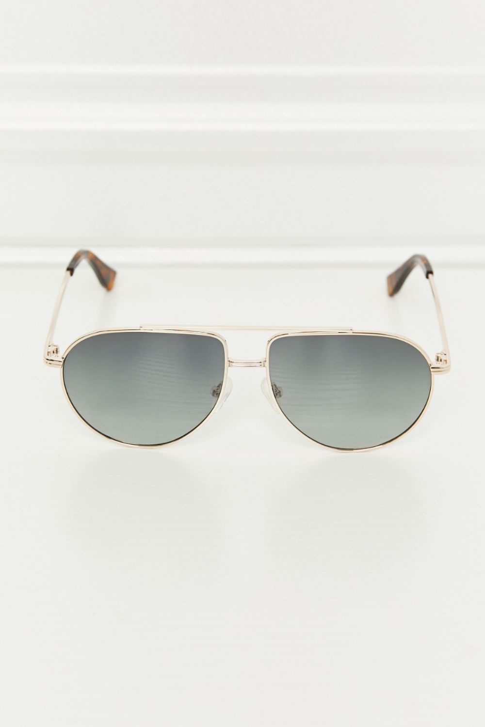 Gradient lens aviator sunglasses with a gold metal frame and tortoise shell temple tips.