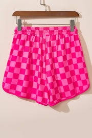 Hot pink checkerboard lounge shorts with elastic waistband and curved hem.