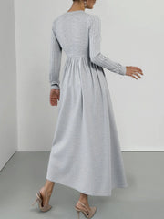 Light gray long sleeve V-neck maxi dress with ribbed sleeves and a flowing skirt.