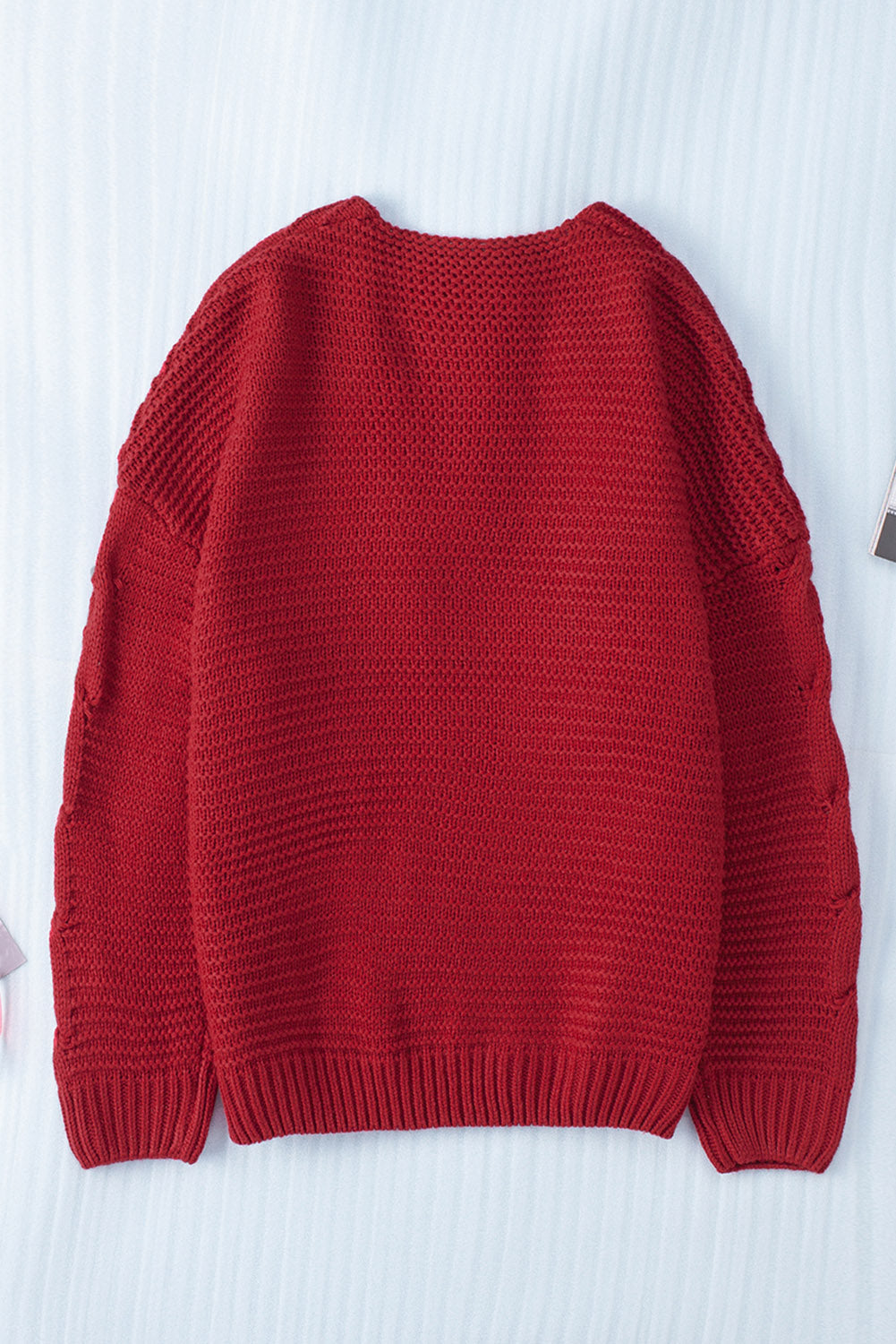 Burgundy cable knit acrylic cardigan with open front and cocoon silhouette.