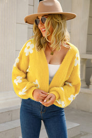 Yellow fuzzy cropped cardigan with white floral print, V-neck, and long sleeves.
