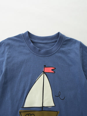 Blue cotton tee with sailboat graphic and red flag detail.