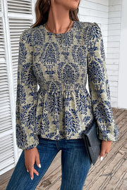 Navy damask print smocked peplum blouse with long sleeves and a crew neck.