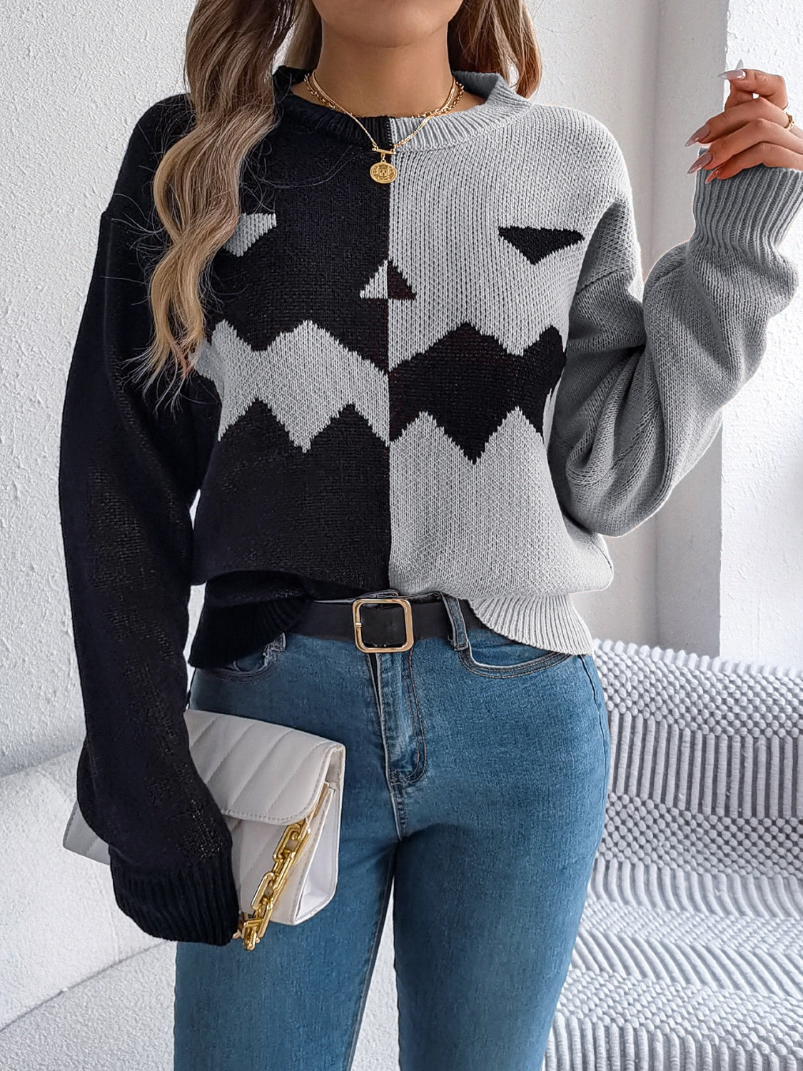 Split-face pumpkin knit sweater in black and gray with a zigzag pattern.