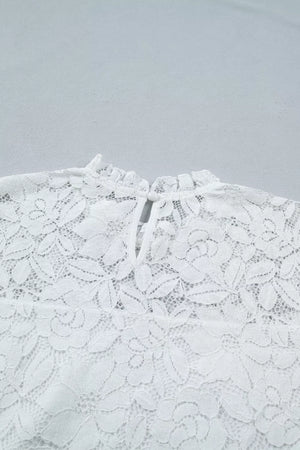 White lace blouse with ruffled neckline and tie closure detail