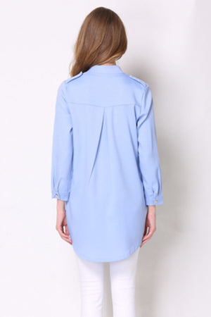 Light blue trench coat with shoulder detailing and buttoned cuffs.