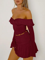 Ruched bodice off-shoulder top in rust with long bell sleeves and a cinched waist.