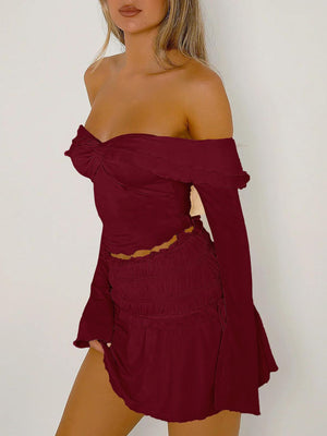 Ruched bodice off-shoulder top in rust with long bell sleeves and a cinched waist.