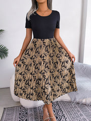 Botanical pleated midi dress with black ribbed top and beige floral skirt.