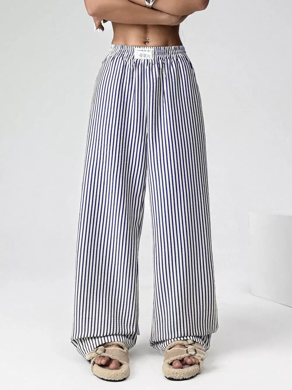 Navy striped high-waisted wide-leg pants with drawstring detail.