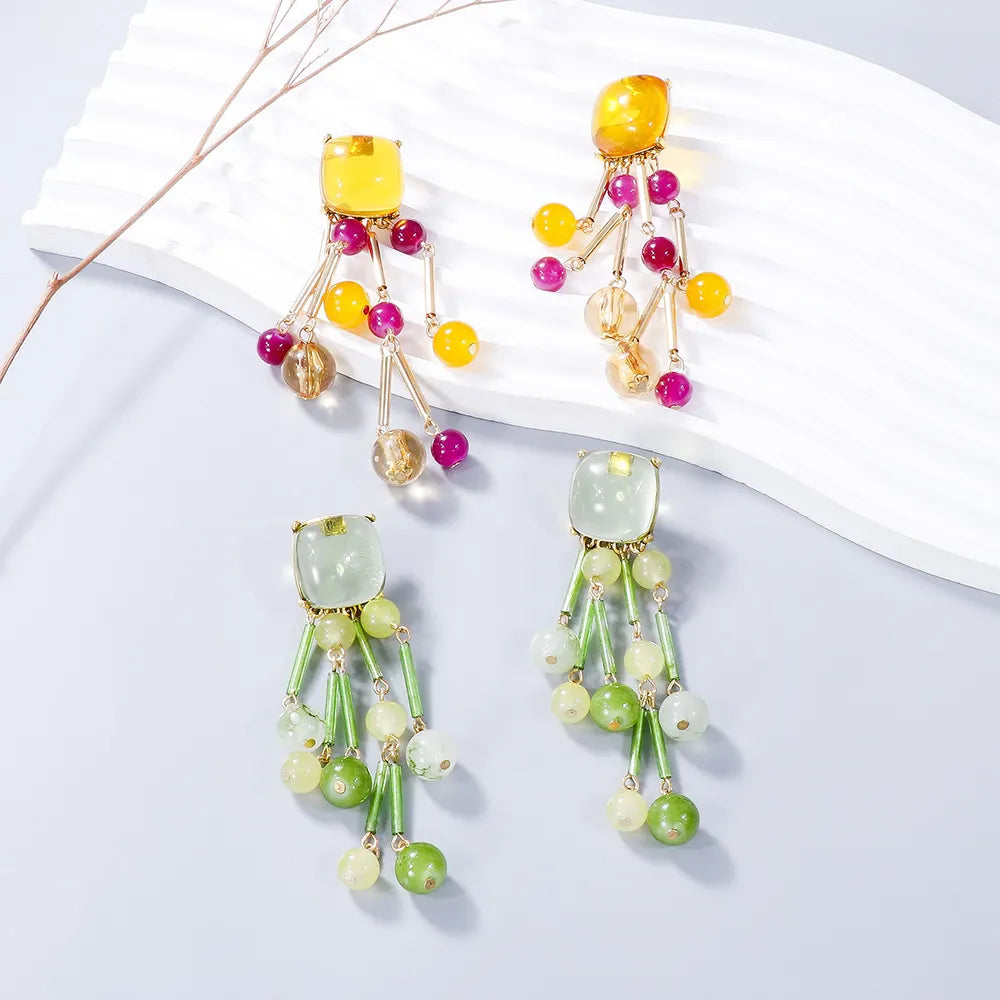 Beaded cascade statement earrings in tangerine and gum leaf feature acrylic and alloy with dangling beads.