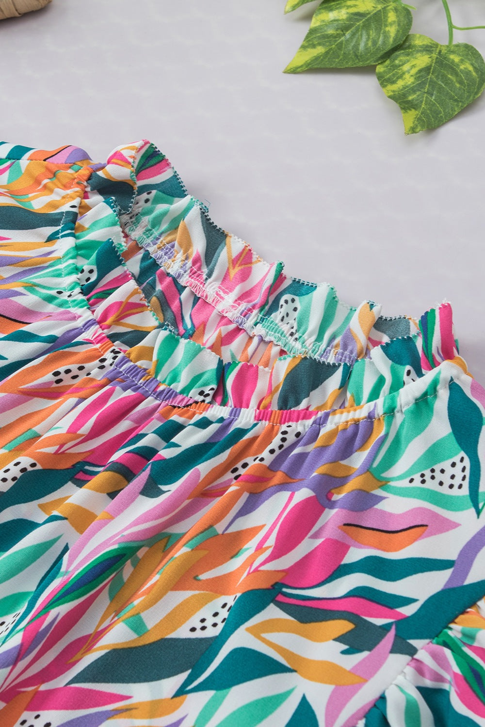 Multicolor leaf print blouse with ruffled collar and elasticated neckline.