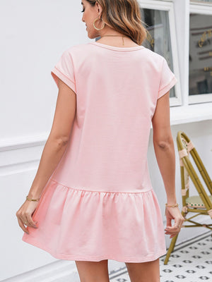 Cap sleeve drop waist t-shirt dress in blush pink cotton with a ruffled hem.