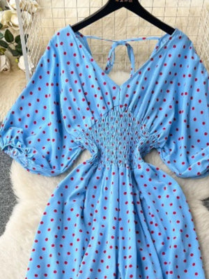 Light Blue polka dot romper with smocked waist and tie neck.