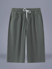 Relaxed cropped sweatpants in Army Green with drawstring waist and pockets.