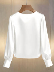 White pearl trim round neck blouse with long balloon sleeves and button cuffs.