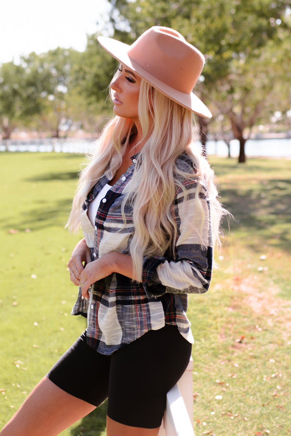 Linen plaid button-down overshirt with a relaxed fit and classic collar, styled open over a white tank top.
