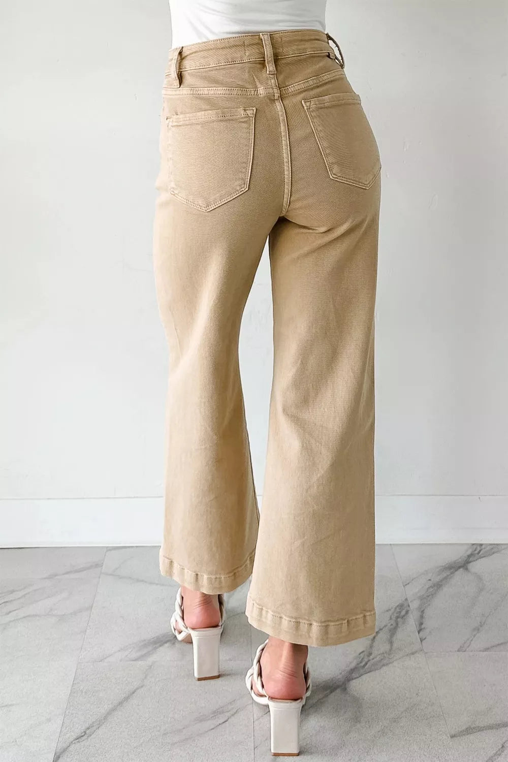 High-waisted cropped wide-leg jeans in tan denim with frayed hem detail.