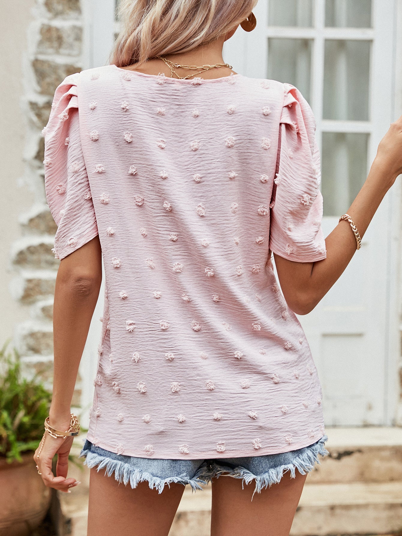 Pink textured dotty puff sleeve blouse with a casual cut.
