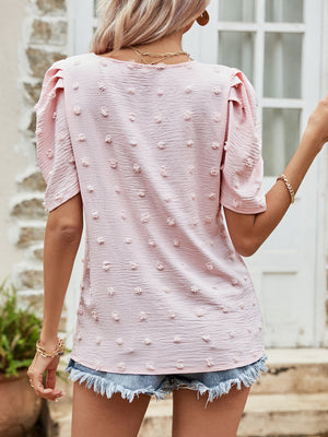 Pink textured dotty puff sleeve blouse with a casual cut.