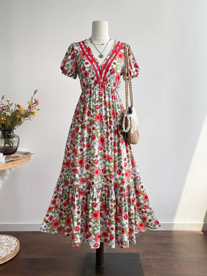 Vibrant floral v-neck midi dress with tiered skirt and red trim.