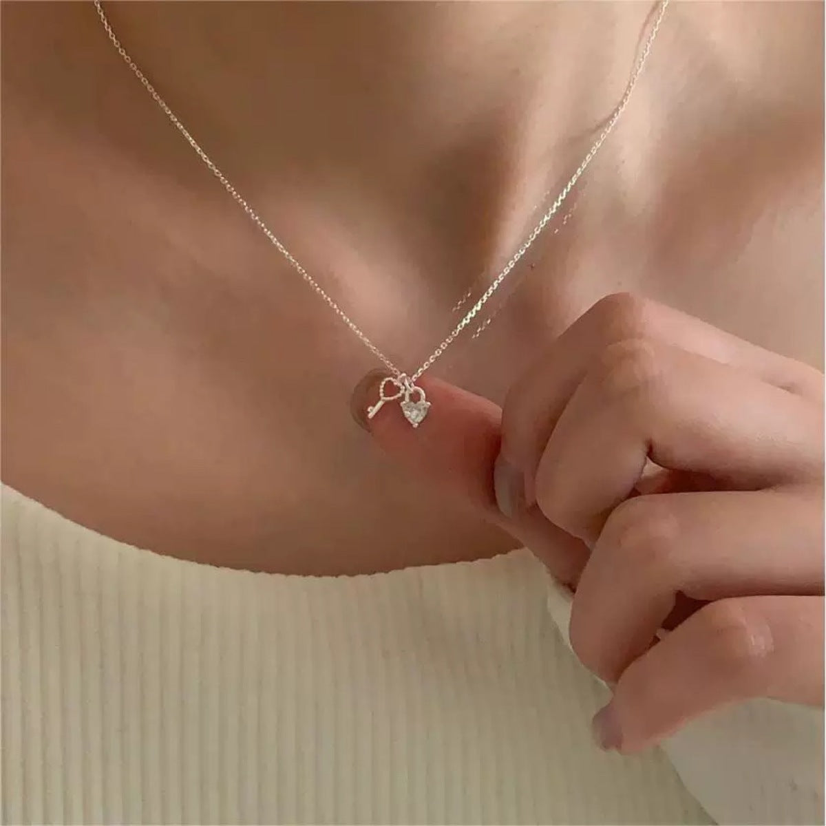 Sterling silver necklace with dainty heart lock and key charms.