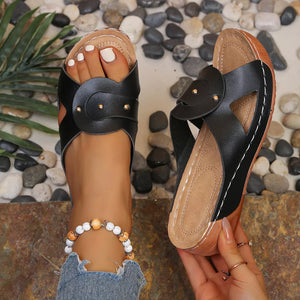Black embellished open-toe wedge sandals with decorative straps and a wooden heel.