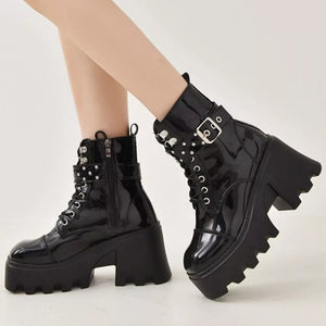 Glossy black platform ankle boots with buckle accents and studded details.