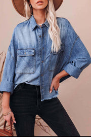 Light wash denim oversized shirt with raw hemline and button-down front.