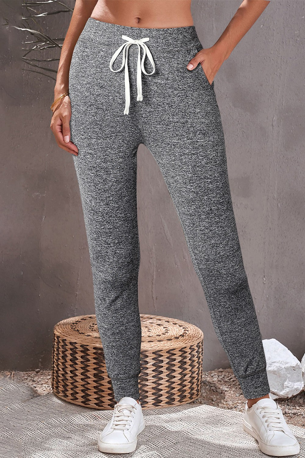 Slim-fit joggers in dark gray heather with white drawstring and pockets.