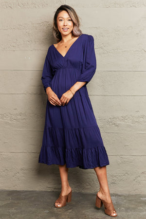 Navy backless empire waist midi dress with tiered skirt and balloon sleeves.