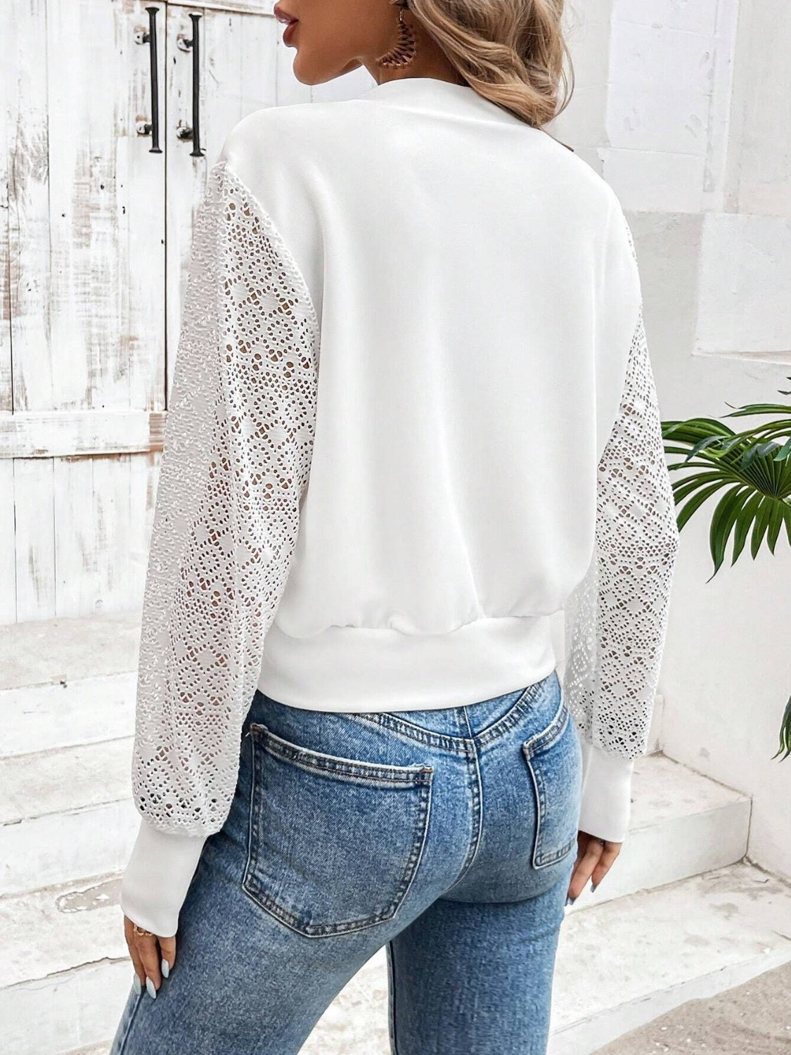 White bomber jacket with lace sleeves and ribbed cuffs and hem.