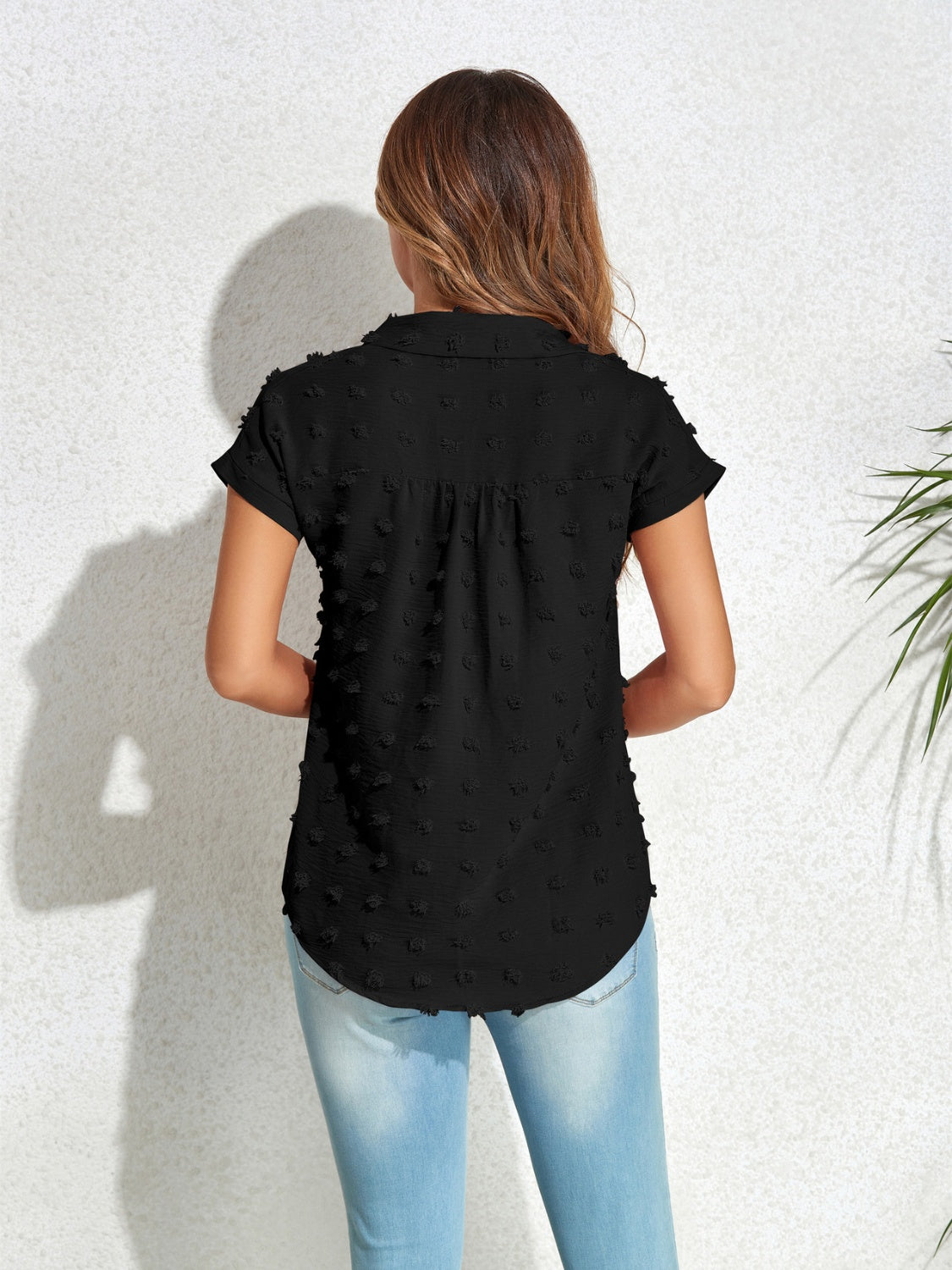 Black textured dot poplin shirt with short sleeves and collar, styled with jeans.