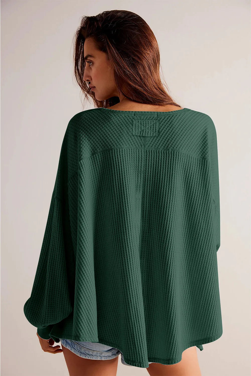 Dark green waffle knit blouson sleeve top with a relaxed fit and wide neckline.