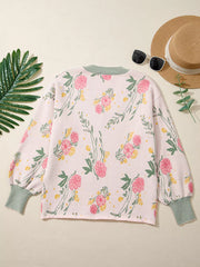 Pink floral V-neck knit sweater with relaxed fit and green striped cuffs.