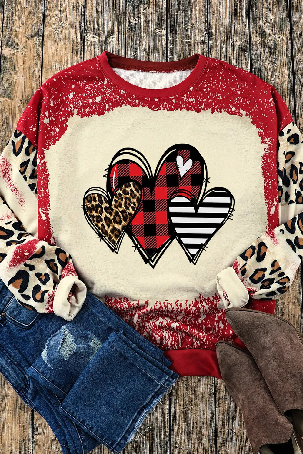 Sweatshirt with heart graphic, buffalo plaid, leopard print, and stripes. Red bleach-dye sleeves.