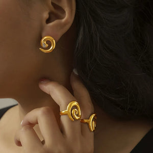 Gold sculptural swirl ring with a modern, artistic design.