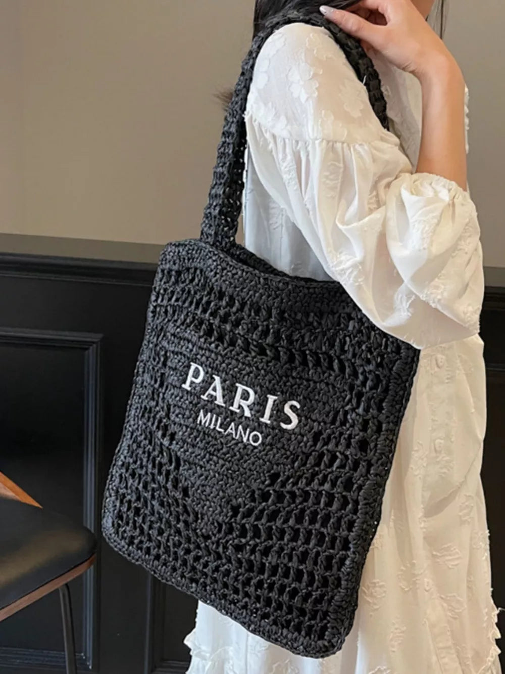 Black crochet tote bag with white PARIS MILANO text detail.