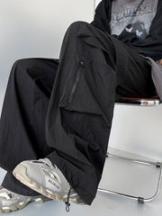 Men's black cargo sweatpants with zippered pocket detail and drawstring hem.