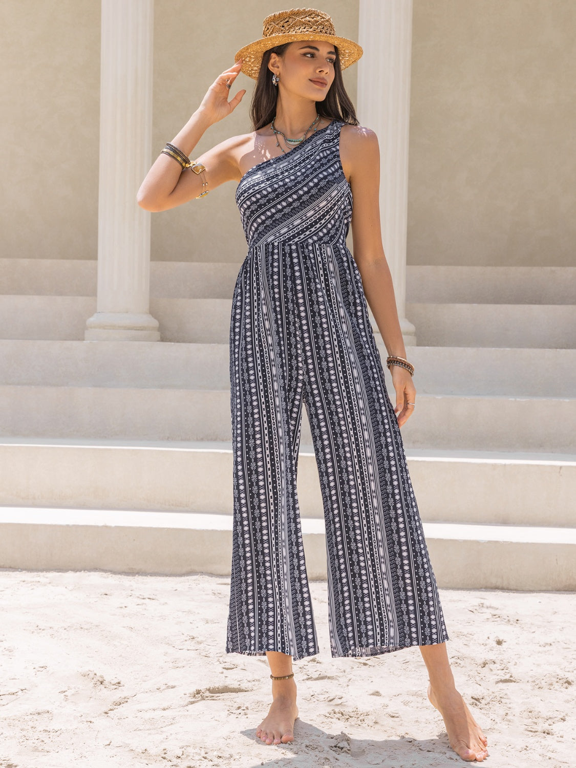 Printed asymmetric palazzo jumpsuit with one shoulder, wide leg, and black and white pattern.